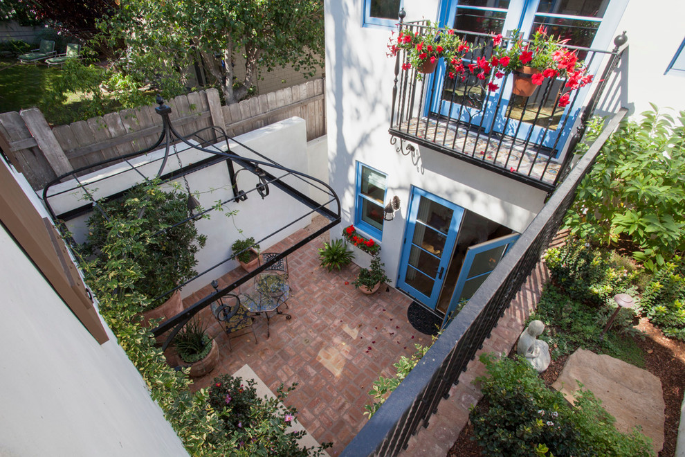 Mid-sized mediterranean side yard patio in San Diego with a container garden, brick pavers and a gazebo/cabana.