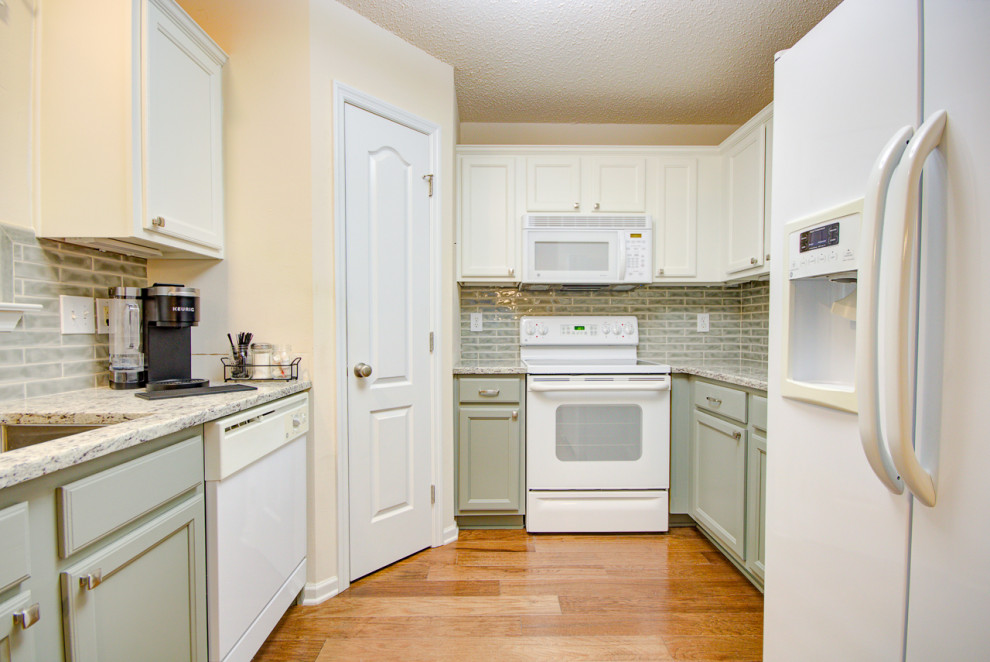 Mid-sized transitional u-shaped medium tone wood floor and brown floor eat-in kitchen photo with an undermount sink, shaker cabinets, green cabinets, granite countertops, green backsplash, ceramic backsplash, white appliances, no island and multicolored countertops