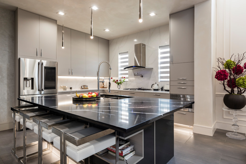 Design ideas for a large contemporary l-shaped open plan kitchen in Orlando with flat-panel cabinets, grey cabinets, quartzite benchtops, white splashback, stone slab splashback, stainless steel appliances, porcelain floors, with island, grey floor, grey benchtop and a double-bowl sink.