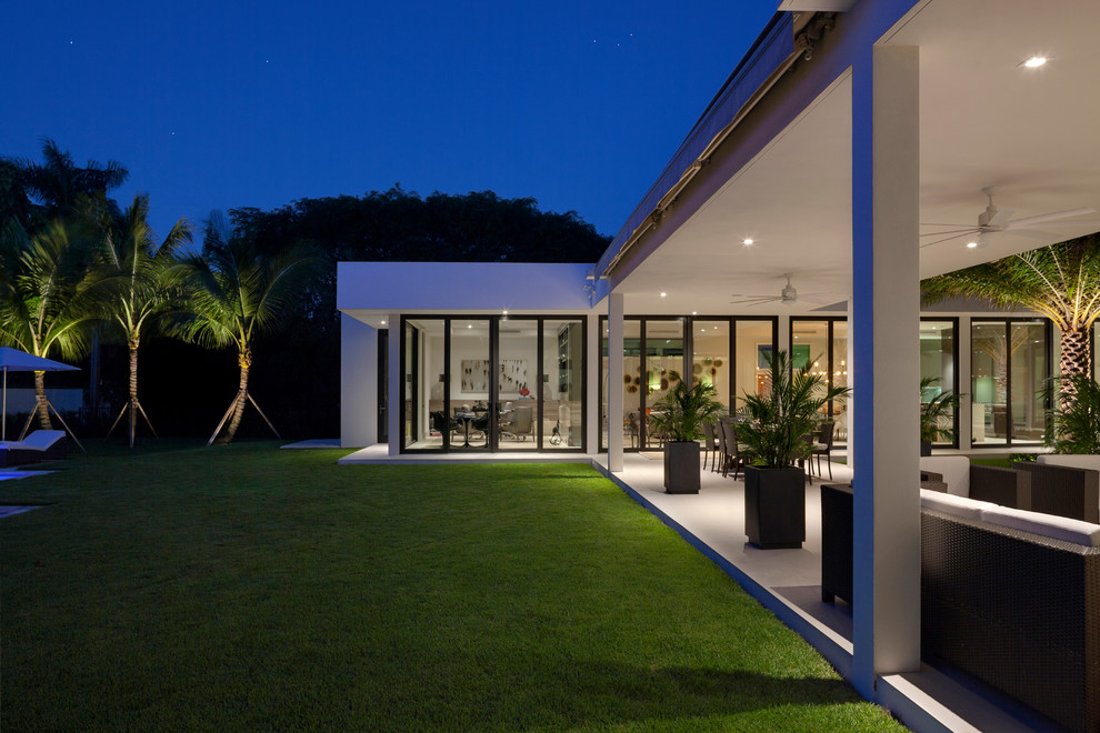 This is an example of an expansive midcentury courtyard patio in Miami with a roof extension.