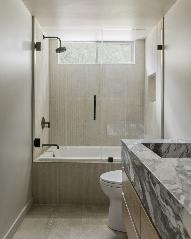 Modern inredning av ett litet flerfärgad flerfärgat badrum, med släta luckor, bruna skåp, en dusch/badkar-kombination, grå kakel, cementkakel, grå väggar, betonggolv, ett integrerad handfat, marmorbänkskiva, grått golv och dusch med gångjärnsdörr