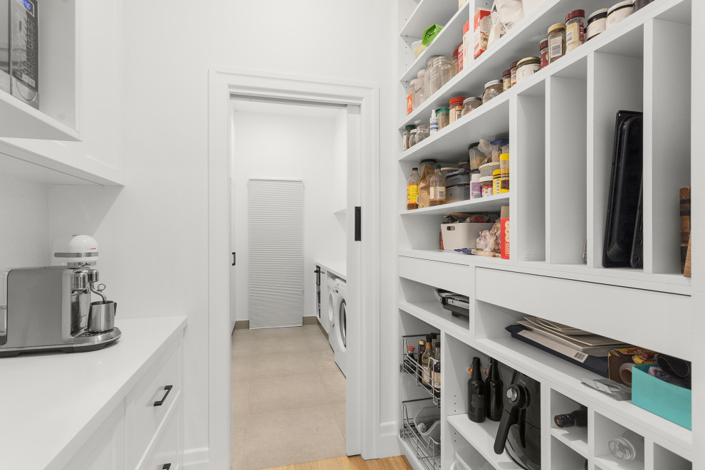 Inspiration for a mid-sized contemporary single-wall kitchen pantry in Melbourne with shaker cabinets, white cabinets, quartz benchtops, white splashback, black appliances, light hardwood floors, beige floor and white benchtop.
