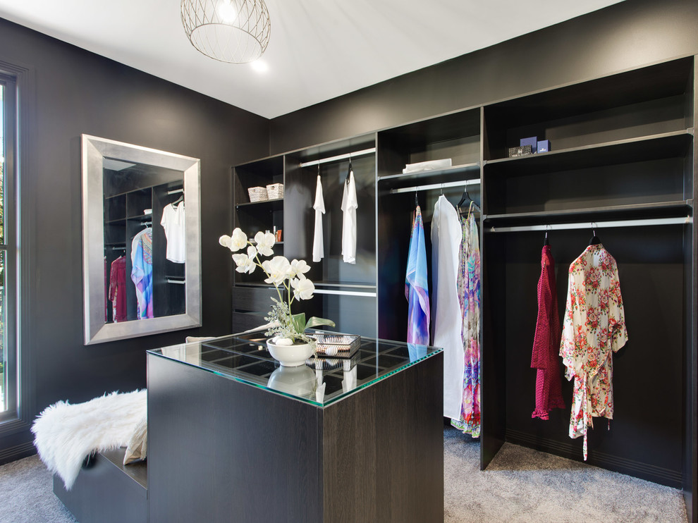 Photo of a contemporary gender-neutral walk-in wardrobe in Brisbane with flat-panel cabinets, dark wood cabinets, carpet and grey floor.