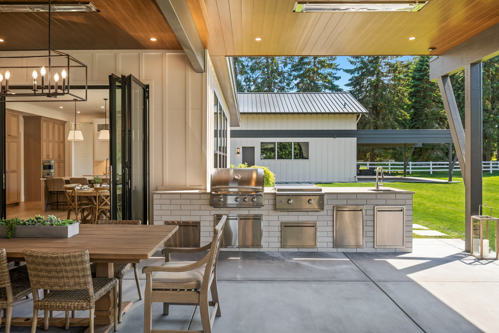 Design ideas for an expansive traditional back patio in Seattle with an outdoor kitchen, concrete slabs and a roof extension.