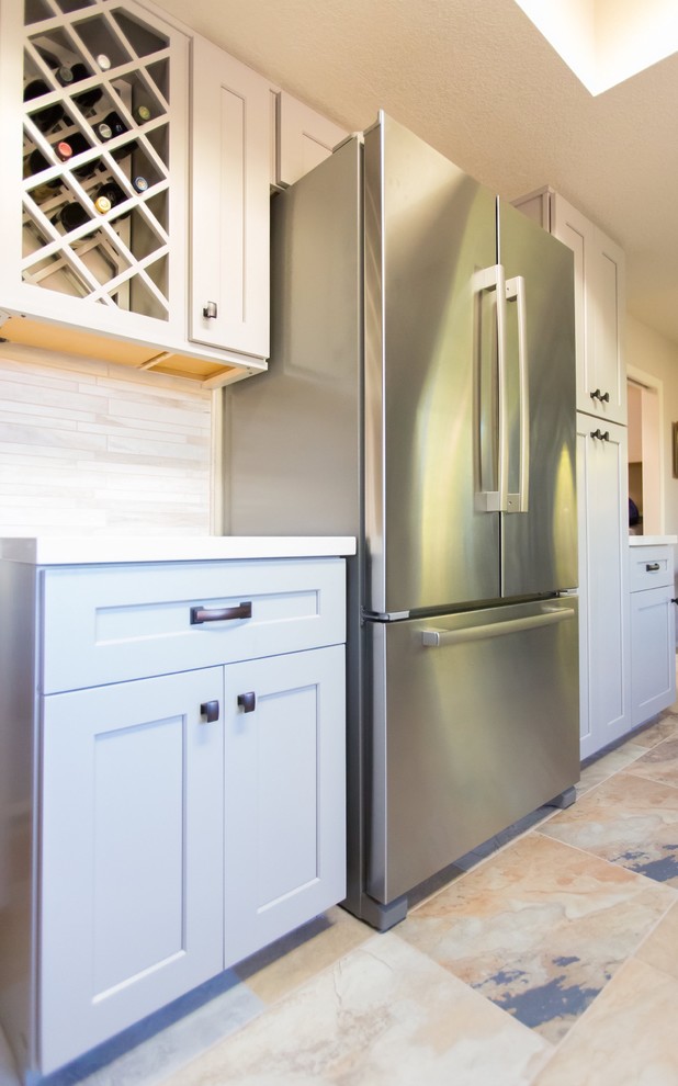 Mid-sized transitional u-shaped porcelain tile kitchen photo in Phoenix with a farmhouse sink, shaker cabinets, gray cabinets, quartz countertops, gray backsplash, porcelain backsplash, stainless steel appliances and a peninsula