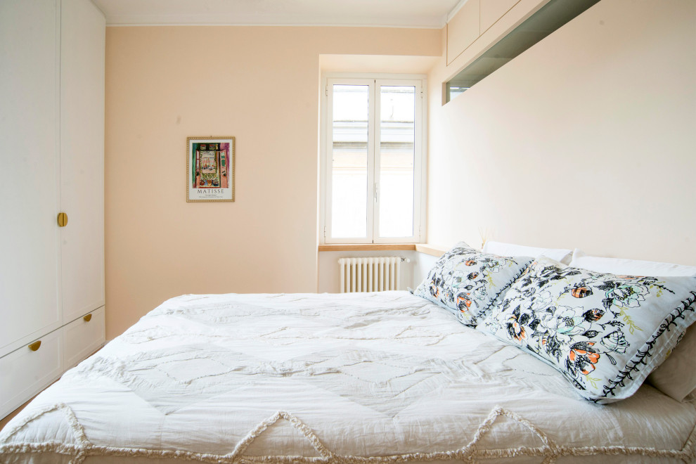 Modelo de dormitorio principal nórdico de tamaño medio sin chimenea con paredes rosas, suelo de madera clara y suelo marrón