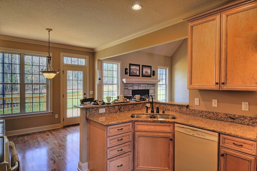 Example of a transitional l-shaped eat-in kitchen design with an undermount sink, flat-panel cabinets, light wood cabinets, granite countertops and colored appliances