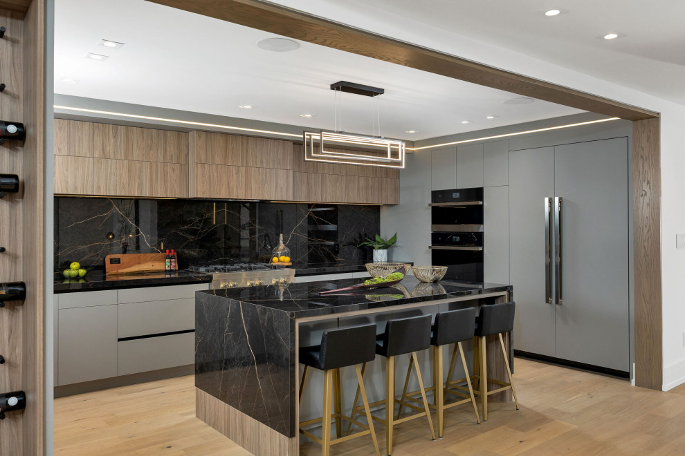 Mid-sized modern u-shaped eat-in kitchen in Toronto with open cabinets, grey cabinets, granite benchtops, black splashback, granite splashback, black appliances, with island, brown floor, black benchtop and recessed.