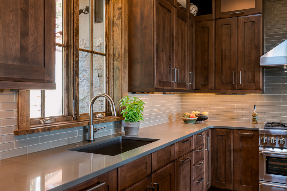 Eat-in kitchen - large transitional u-shaped medium tone wood floor eat-in kitchen idea with an undermount sink, shaker cabinets, dark wood cabinets, quartz countertops, gray backsplash, glass tile backsplash, stainless steel appliances and an island