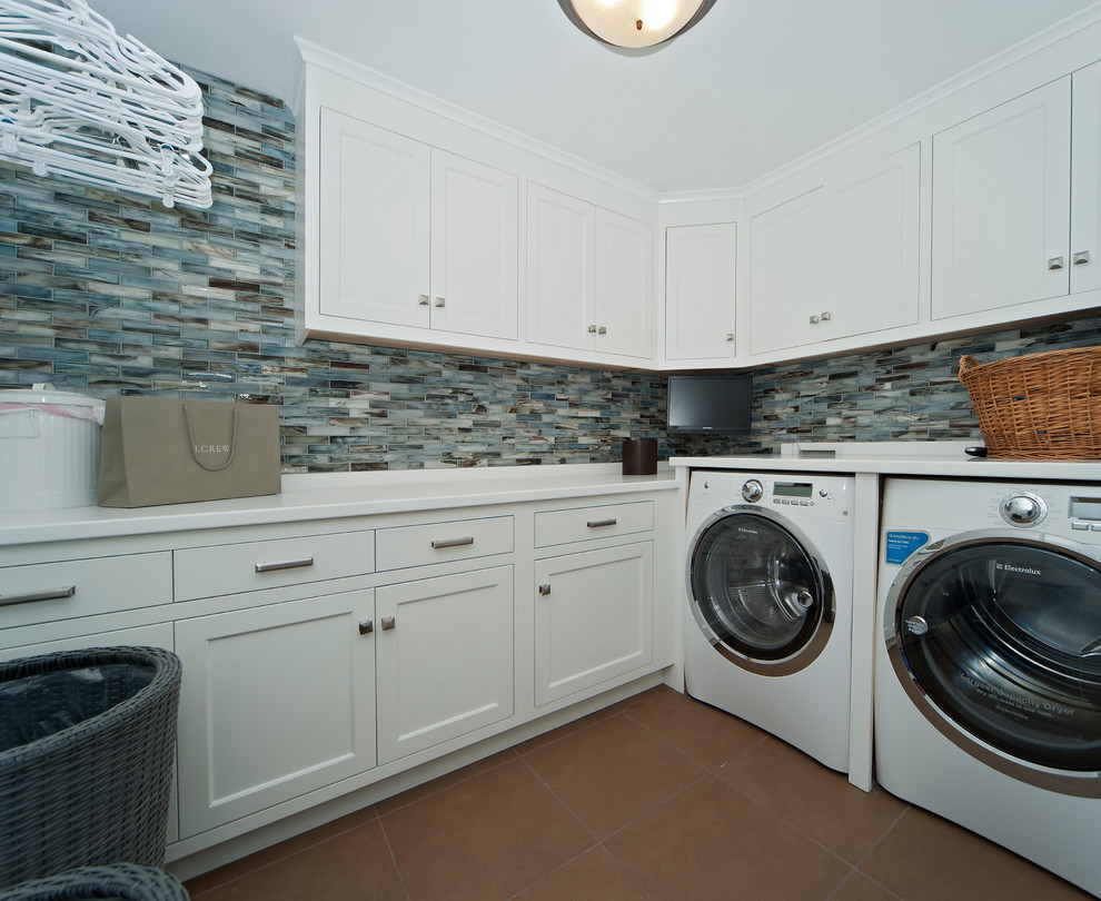 Mid-sized eclectic l-shaped dedicated laundry room in Boston with shaker cabinets, white cabinets, solid surface benchtops, porcelain floors and a side-by-side washer and dryer.