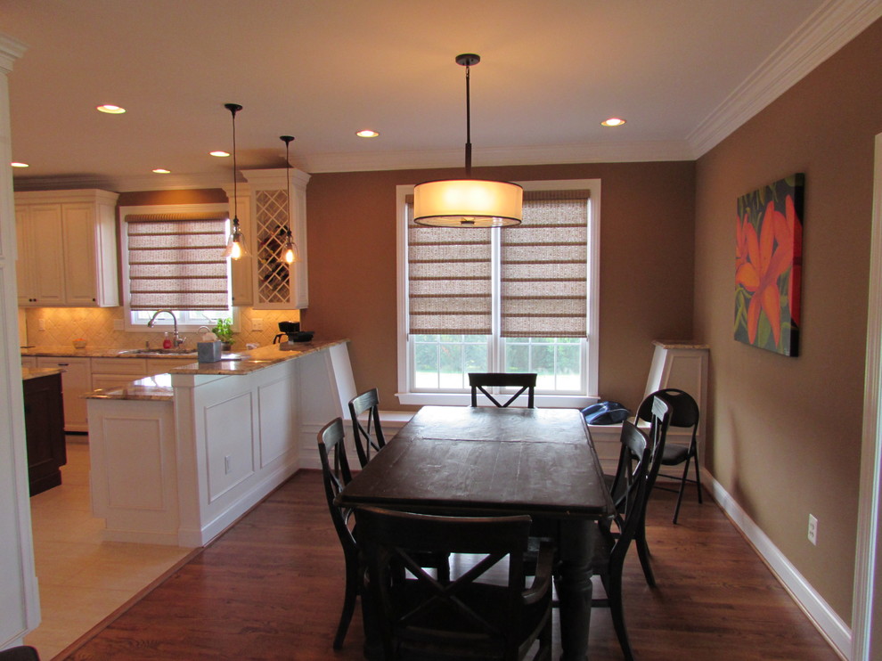 Example of a large transitional l-shaped ceramic tile eat-in kitchen design in Baltimore with an undermount sink, raised-panel cabinets, white cabinets, granite countertops, beige backsplash, ceramic backsplash, stainless steel appliances and an island