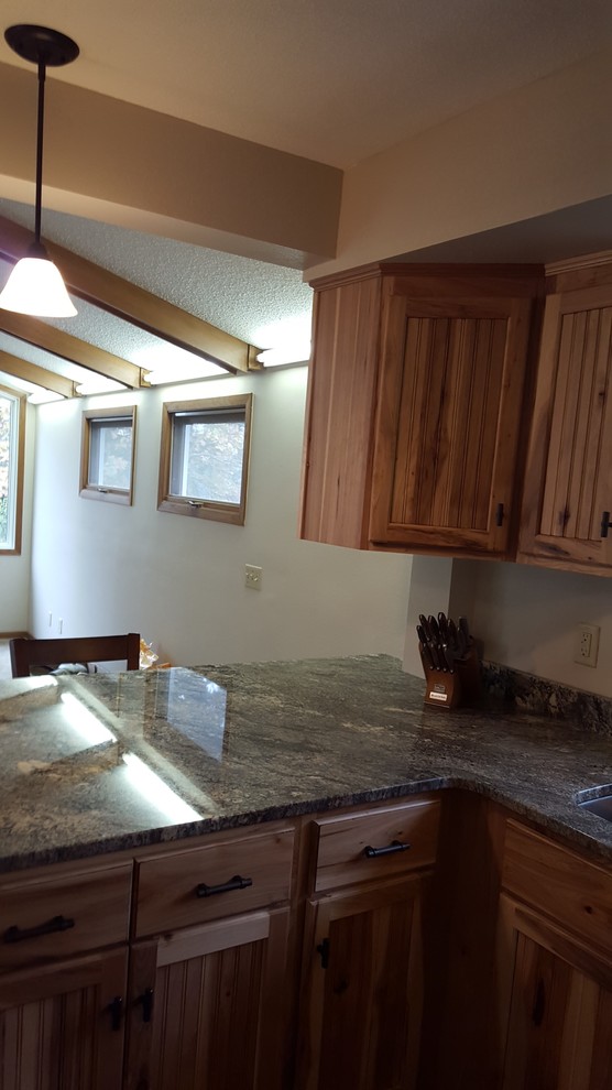 Eat-in kitchen - u-shaped dark wood floor eat-in kitchen idea with an undermount sink, stainless steel appliances and a peninsula
