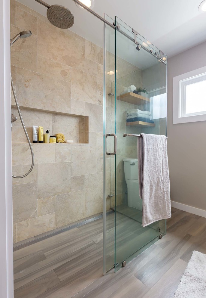 Mid-sized contemporary master bathroom in Los Angeles with flat-panel cabinets, light wood cabinets, a curbless shower, a two-piece toilet, beige tile, travertine, beige walls, porcelain floors, a vessel sink, engineered quartz benchtops, brown floor and a sliding shower screen.