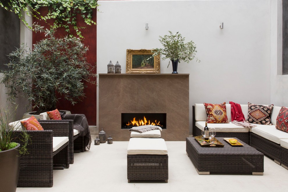 Mid-sized asian patio in London with a fire feature and natural stone pavers.