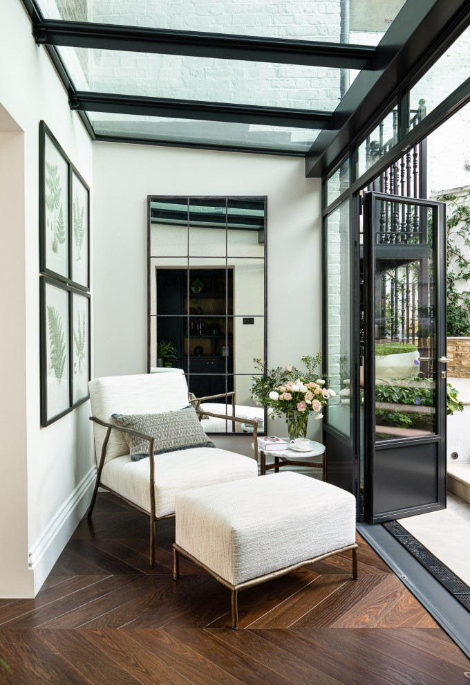Inspiration for a small transitional sunroom in London with dark hardwood floors, a glass ceiling, brown floor and no fireplace.