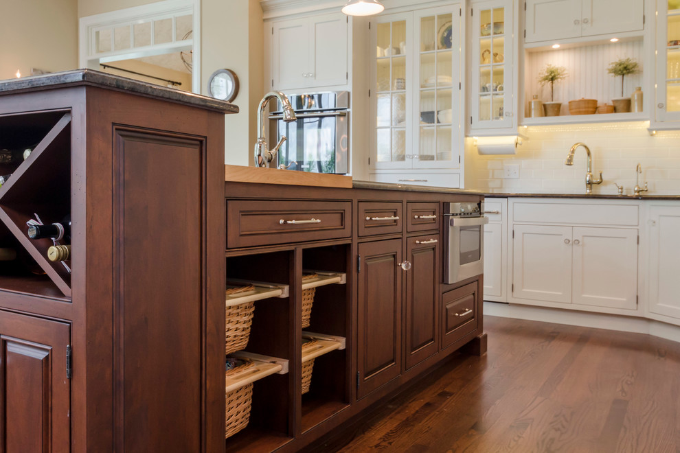 Example of a large transitional l-shaped light wood floor open concept kitchen design in Chicago with an island, glass-front cabinets, yellow cabinets, white backsplash and ceramic backsplash
