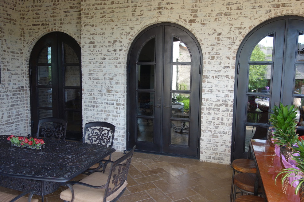 This is an example of a mid-sized traditional backyard patio with natural stone pavers.