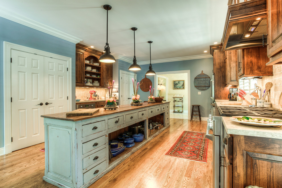 This is an example of a large country kitchen in Kansas City with an undermount sink, dark wood cabinets, wood benchtops, medium hardwood floors and with island.