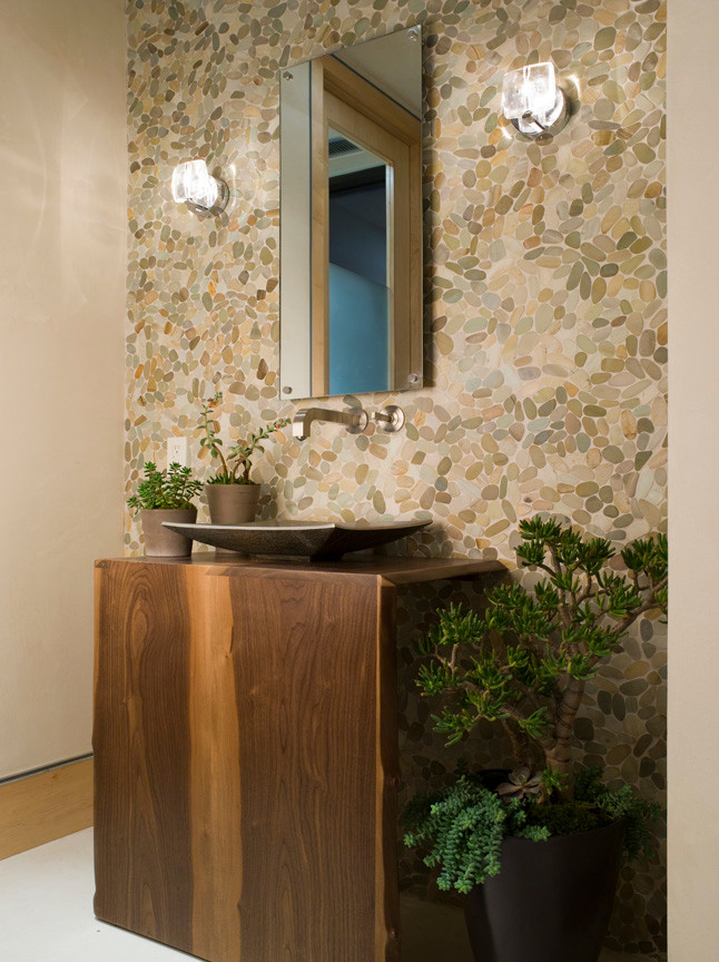 Contemporary powder room in Los Angeles with a vessel sink, medium wood cabinets, wood benchtops, multi-coloured tile, pebble tile and brown benchtops.