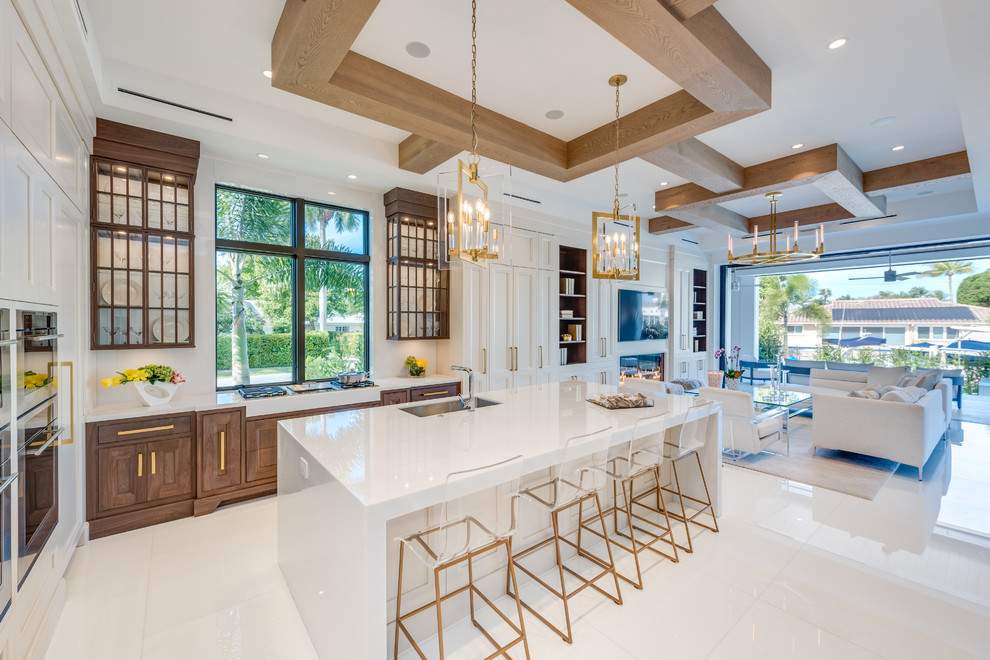 Transitional u-shaped white floor open concept kitchen photo in Miami with an undermount sink, recessed-panel cabinets, white cabinets, an island and white countertops