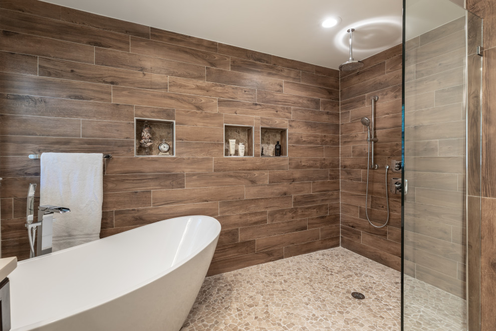 Idéer för att renovera ett mellanstort funkis vit vitt en-suite badrum, med bruna skåp, ett fristående badkar, en dusch/badkar-kombination, en toalettstol med hel cisternkåpa, brun kakel, grå väggar, ett undermonterad handfat, grått golv och med dusch som är öppen