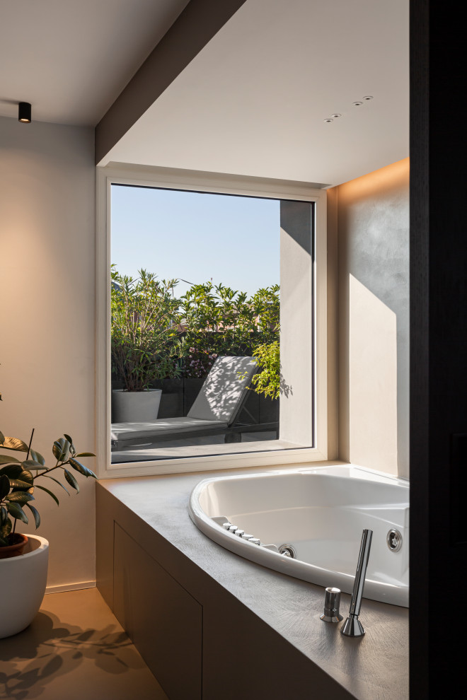 Small contemporary bathroom in Milan with flat-panel cabinets, white cabinets, a hot tub, a shower/bathtub combo, green tile, glass tile, grey walls, concrete floors, grey floor, a hinged shower door, grey benchtops, a niche, a built-in vanity and recessed.