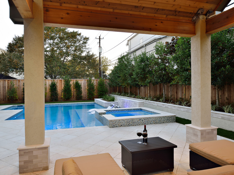 This is an example of a small contemporary backyard rectangular natural pool in Houston with natural stone pavers and a hot tub.