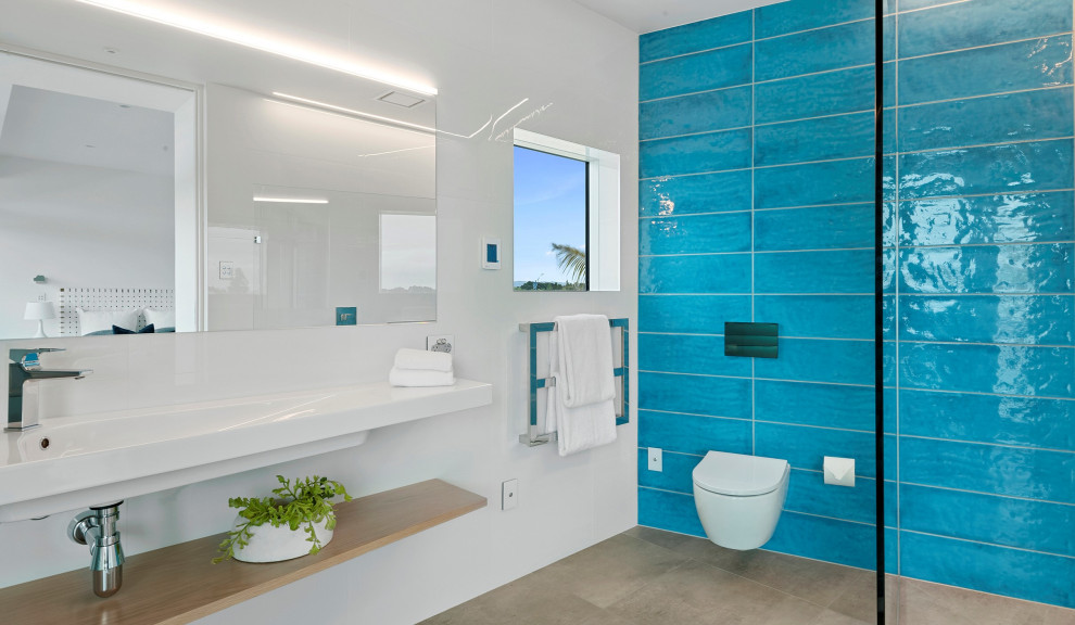 Inspiration för ett stort industriellt vit vitt en-suite badrum, med vita skåp, en vägghängd toalettstol, blå kakel, vita väggar, klinkergolv i porslin, ett integrerad handfat, beiget golv och med dusch som är öppen