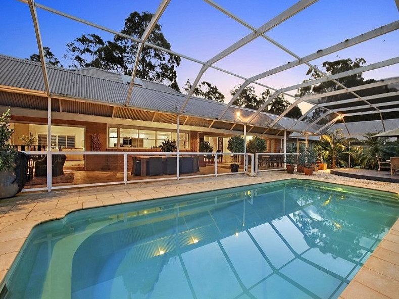 This is an example of a large contemporary pool in Brisbane with a pool house.