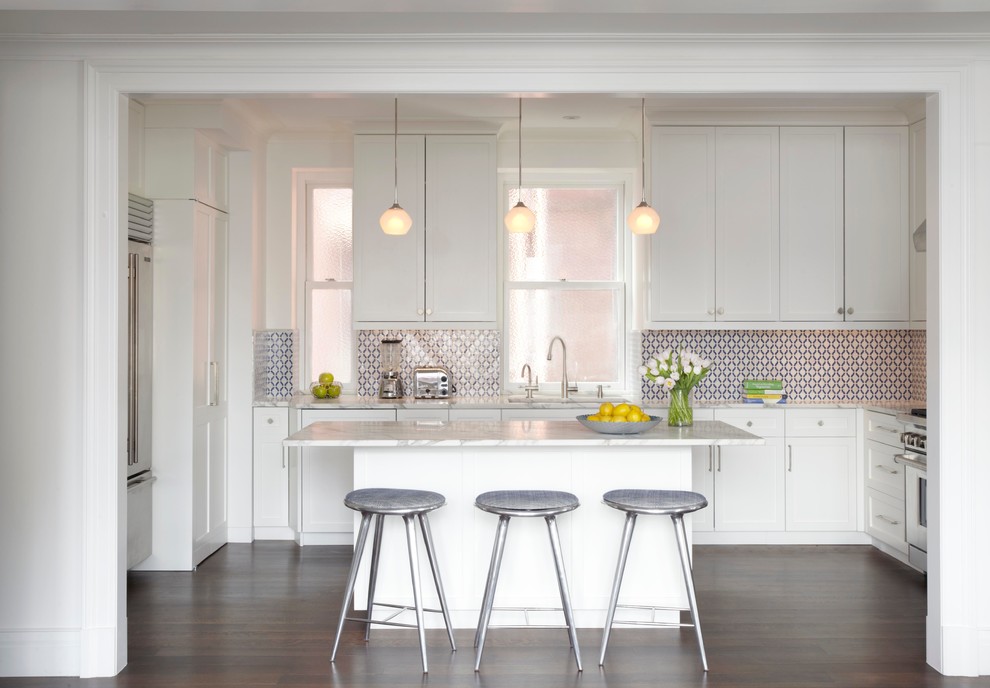 This is an example of a mid-sized transitional u-shaped kitchen in New York with shaker cabinets, white cabinets, multi-coloured splashback, dark hardwood floors and with island.
