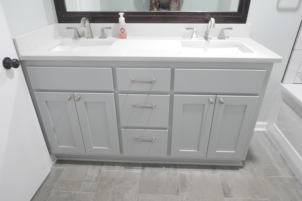 Example of a mid-sized transitional kids' white tile and porcelain tile porcelain tile and gray floor alcove bathtub design with shaker cabinets, gray cabinets, a two-piece toilet, green walls, an undermount sink, quartz countertops and white countertops