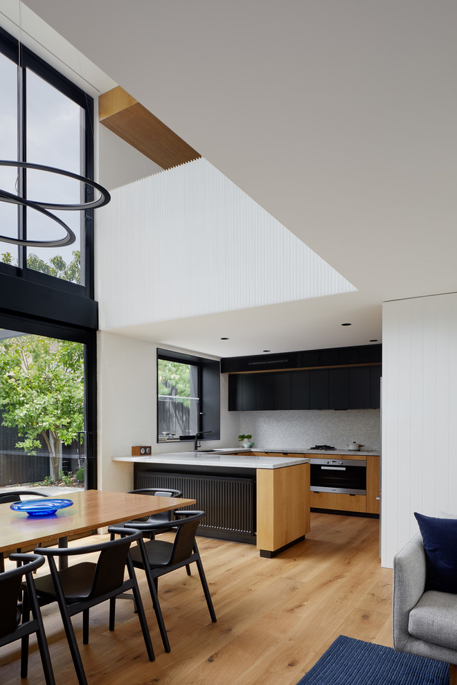 Small contemporary open plan dining in Melbourne with white walls, medium hardwood floors and brown floor.
