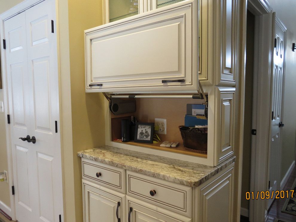 Eat-in kitchen - mid-sized transitional l-shaped ceramic tile eat-in kitchen idea with an undermount sink, raised-panel cabinets, distressed cabinets, granite countertops, white backsplash, porcelain backsplash, stainless steel appliances and an island