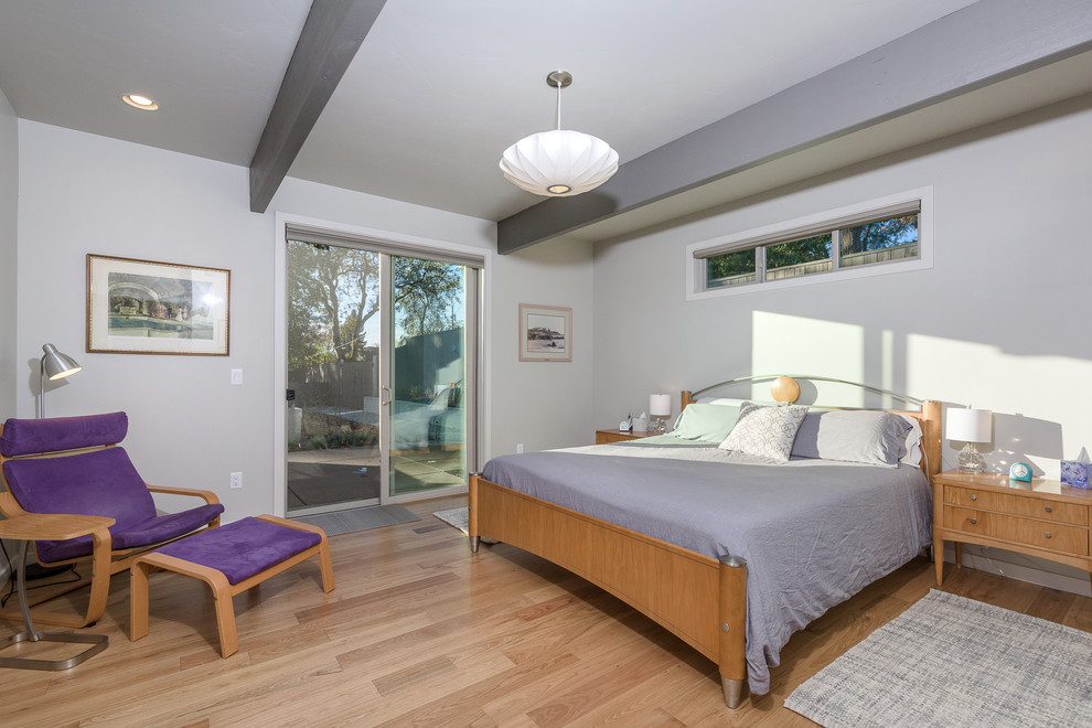 Mid-sized midcentury guest bedroom in Portland with grey walls, light hardwood floors and beige floor.
