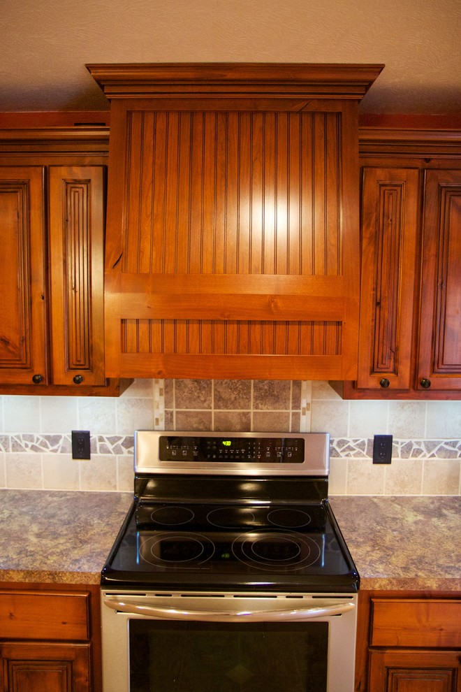 Large u-shaped open concept kitchen photo with a drop-in sink, raised-panel cabinets, medium tone wood cabinets, beige backsplash, ceramic backsplash, stainless steel appliances and an island