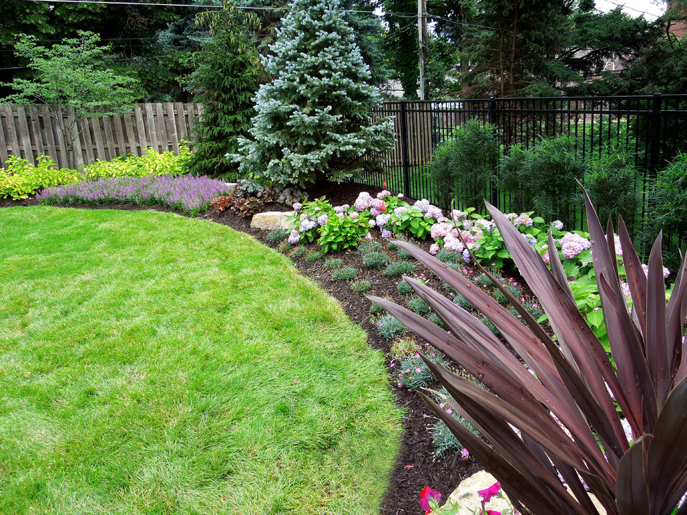 Photo of a mid-sized traditional backyard formal garden in Omaha.