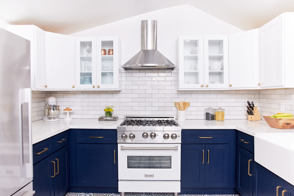 Idéer för ett mellanstort eklektiskt vit kök, med en rustik diskho, skåp i shakerstil, blå skåp, bänkskiva i kvartsit, beige stänkskydd, stänkskydd i stenkakel, rostfria vitvaror, klinkergolv i keramik, en halv köksö och flerfärgat golv