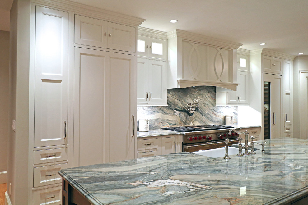 This is an example of a large transitional single-wall eat-in kitchen in Boston with a farmhouse sink, beaded inset cabinets, white cabinets, granite benchtops, multi-coloured splashback, stone slab splashback, stainless steel appliances, light hardwood floors, multiple islands, yellow floor and multi-coloured benchtop.