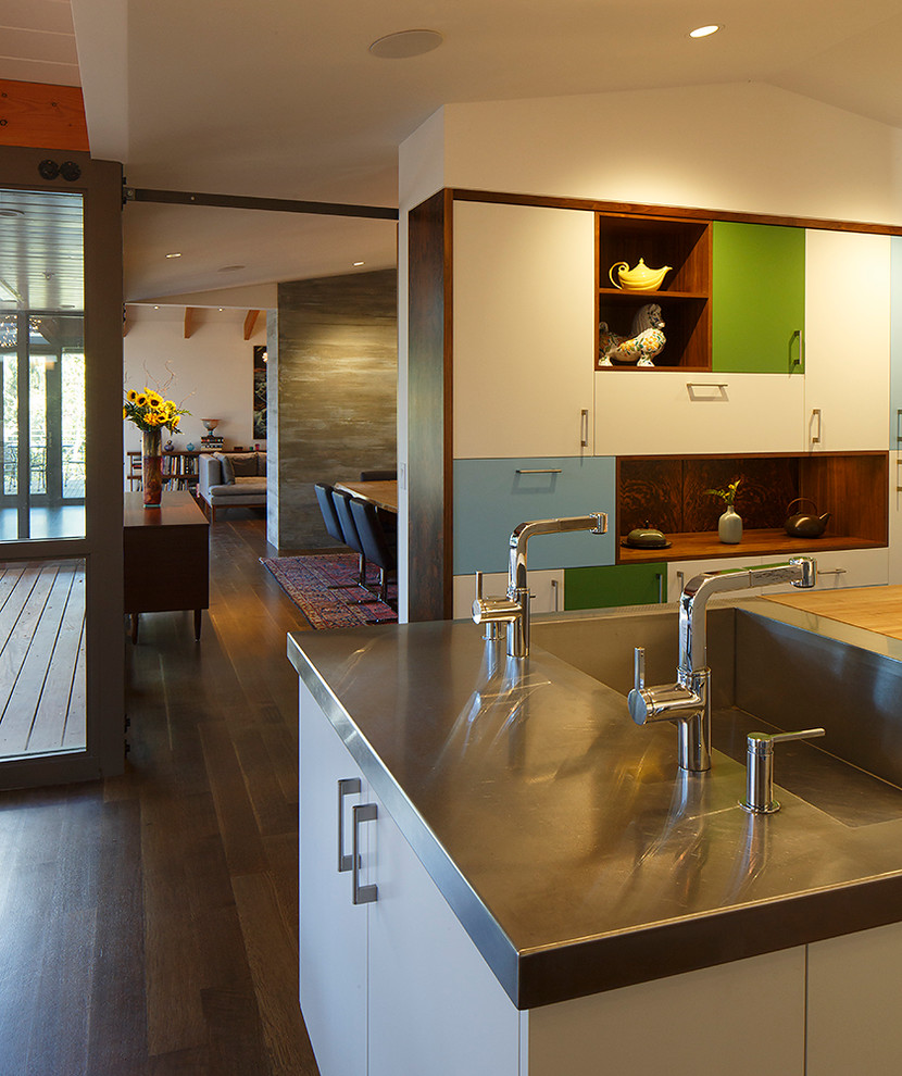 Inspiration for a large midcentury galley eat-in kitchen in San Francisco with an integrated sink, flat-panel cabinets, white cabinets, wood benchtops, white splashback, glass sheet splashback, stainless steel appliances, medium hardwood floors and with island.