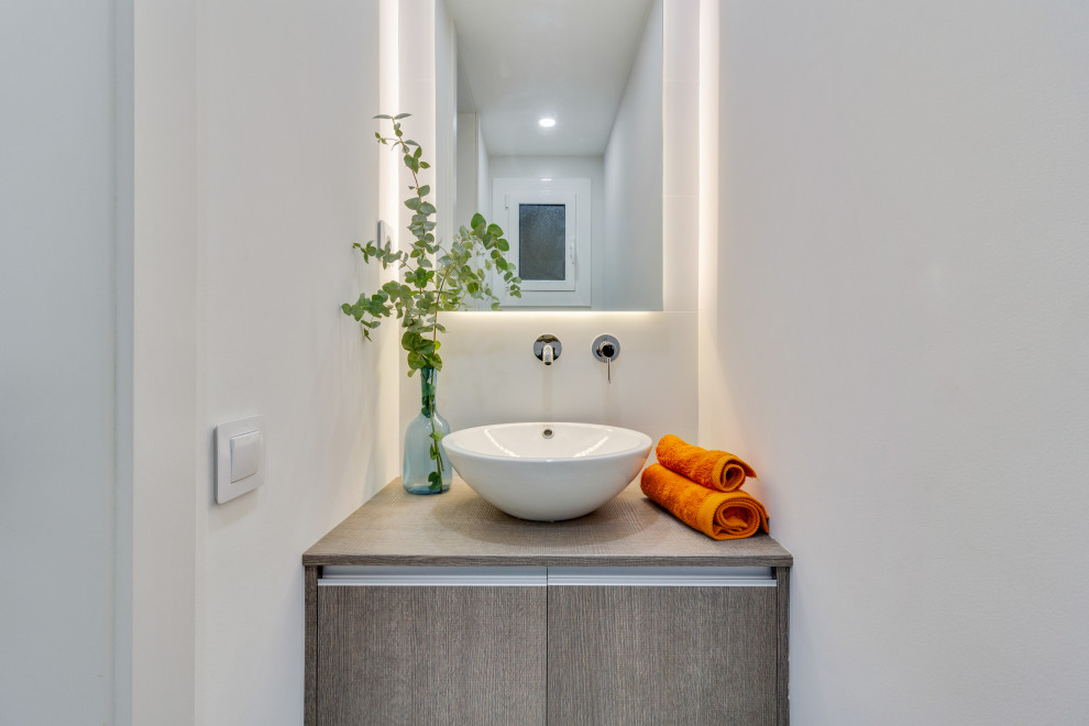 Mid-sized contemporary powder room in Barcelona with shaker cabinets, white cabinets, a two-piece toilet, blue tile, ceramic tile, white walls, porcelain floors, a vessel sink, engineered quartz benchtops, white floor, white benchtops and a built-in vanity.