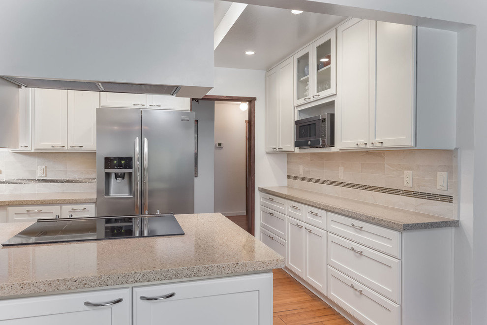 Inspiration for a mid-sized contemporary u-shaped eat-in kitchen in San Francisco with an undermount sink, shaker cabinets, white cabinets, quartz benchtops, beige splashback, ceramic splashback, stainless steel appliances, medium hardwood floors, a peninsula and brown floor.