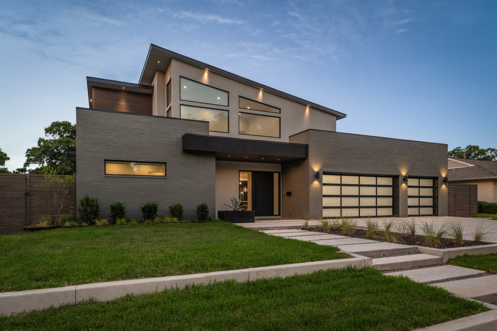 Photo of a modern two-storey stucco grey house exterior in Dallas with a flat roof and a metal roof.