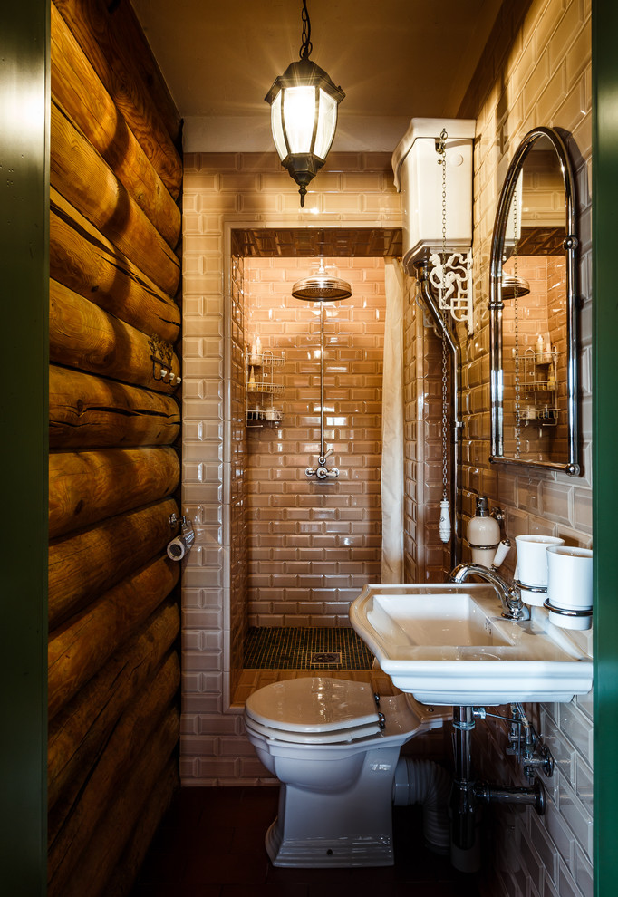 Photo of a country 3/4 bathroom in Other with an alcove shower, a two-piece toilet, beige tile, subway tile, brown walls, a wall-mount sink and a shower curtain.