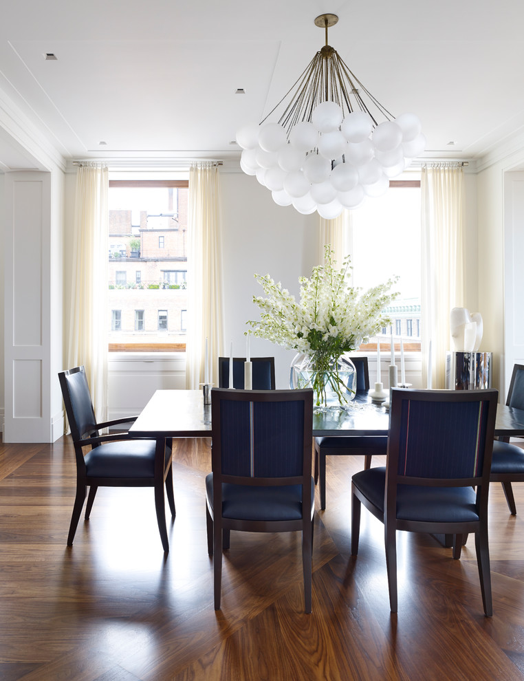Transitional dining room in New York with white walls and medium hardwood floors.
