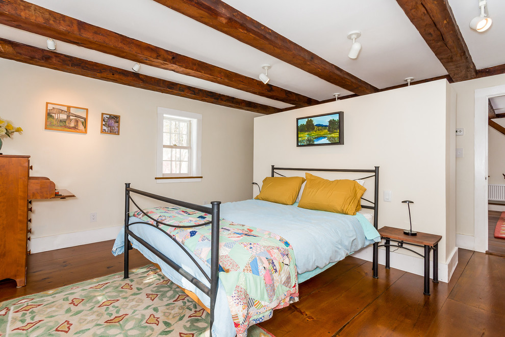 Country bedroom in Boston with beige walls, dark hardwood floors and brown floor.