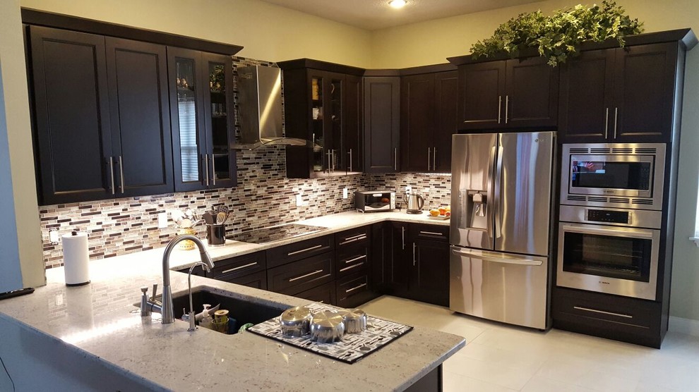 Photo of a transitional u-shaped open plan kitchen in Orlando with an undermount sink, shaker cabinets, dark wood cabinets, granite benchtops, brown splashback, matchstick tile splashback, stainless steel appliances, porcelain floors and a peninsula.