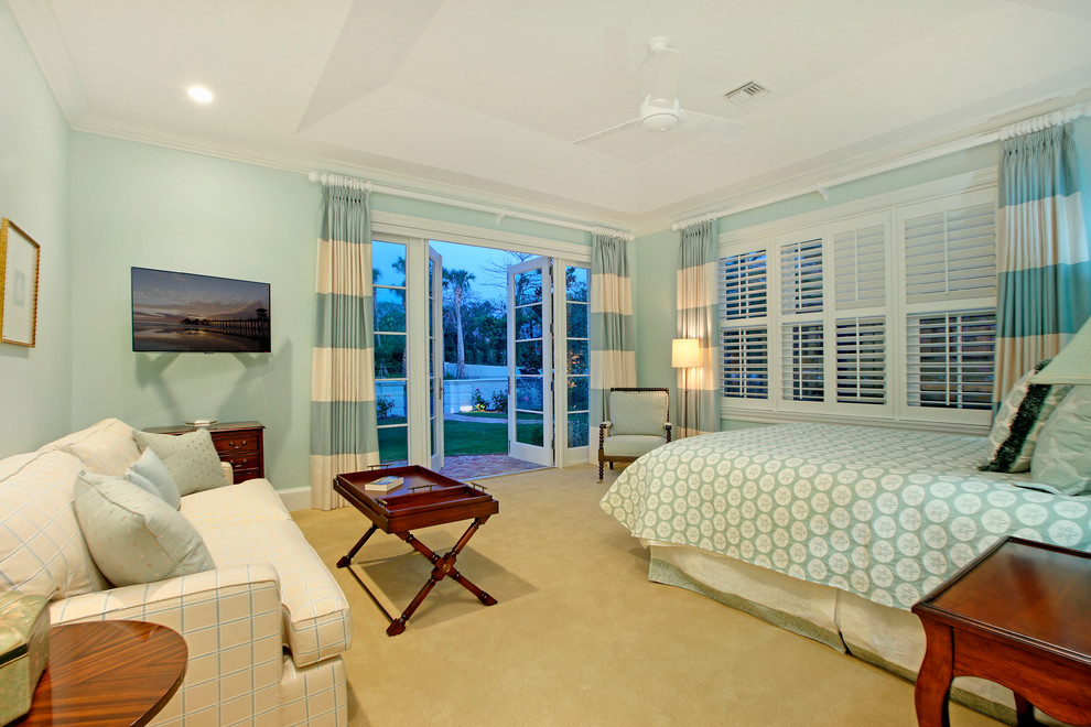 Expansive beach style guest bedroom in Miami with blue walls, carpet and no fireplace.