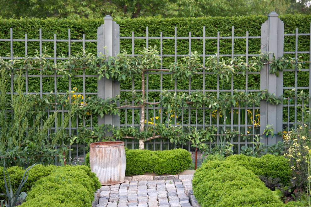 This is an example of a large country backyard formal garden in New York with a vegetable garden and natural stone pavers.