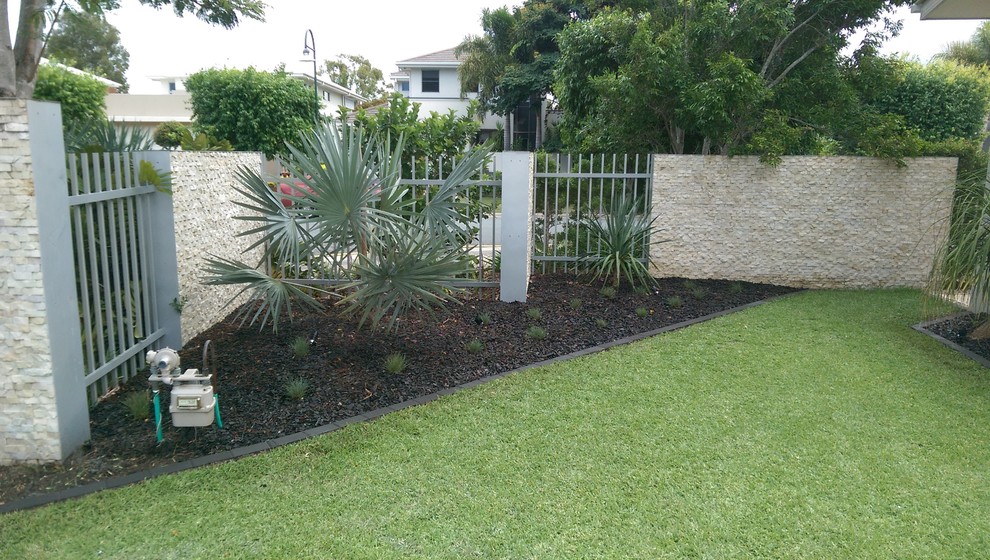 This is an example of a tropical front yard partial sun garden in Gold Coast - Tweed with mulch.