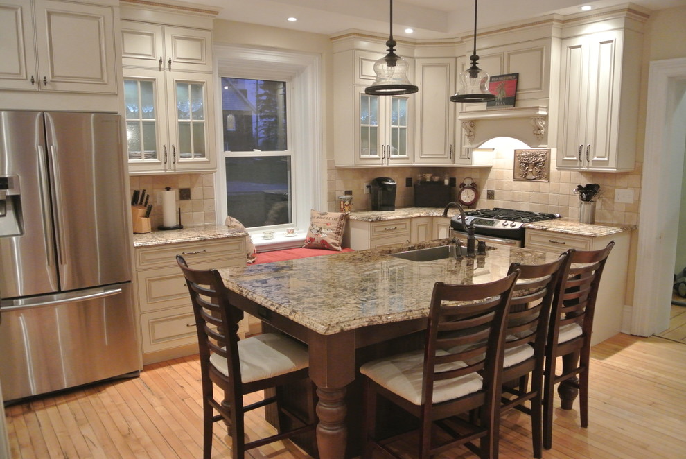 Photo of a large country l-shaped separate kitchen in Toronto with an undermount sink, raised-panel cabinets, distressed cabinets, granite benchtops, beige splashback, stainless steel appliances and with island.